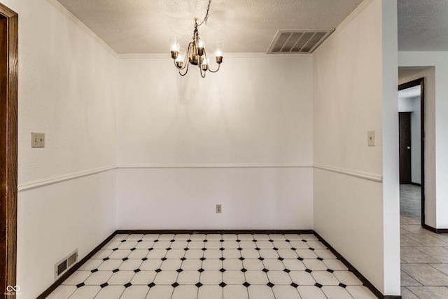 unfurnished dining area with crown molding, visible vents, a notable chandelier, and a textured ceiling