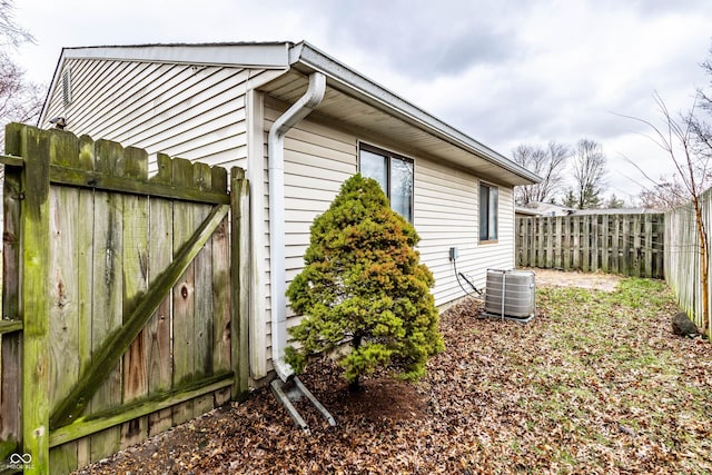 view of property exterior with cooling unit and fence