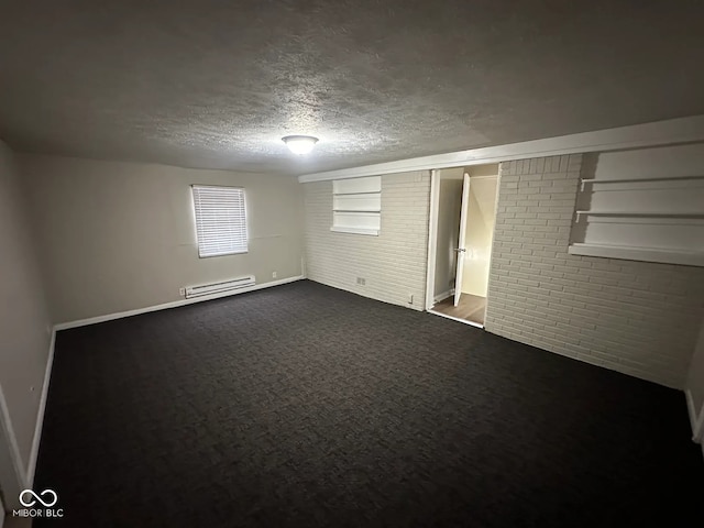 unfurnished room with dark carpet, baseboard heating, a textured ceiling, brick wall, and baseboards