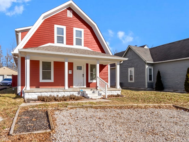 dutch colonial with a porch, a shingled roof, and a gambrel roof