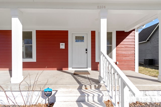 doorway to property featuring a porch and cooling unit