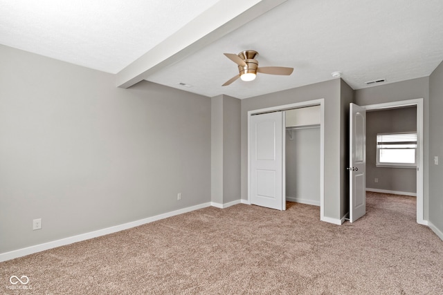 unfurnished bedroom featuring a closet, carpet, visible vents, and baseboards