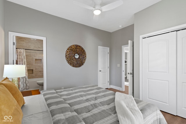 bedroom with a closet, ensuite bathroom, ceiling fan, wood finished floors, and baseboards