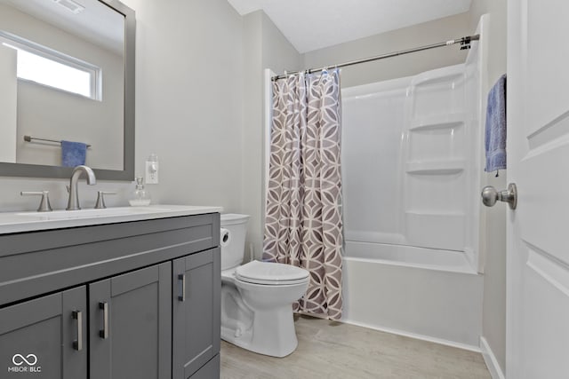 bathroom featuring visible vents, toilet, wood finished floors, shower / bath combination with curtain, and vanity