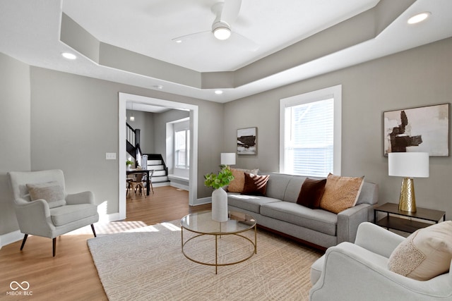 living area featuring baseboards, plenty of natural light, and light wood finished floors