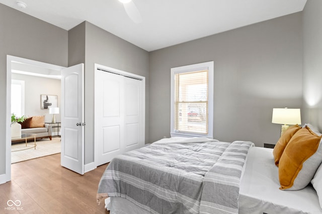 bedroom featuring light wood finished floors, a ceiling fan, and a closet