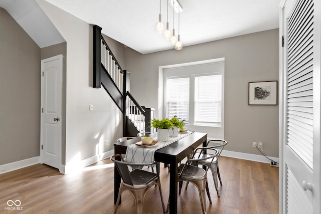 dining space featuring stairway, wood finished floors, and baseboards