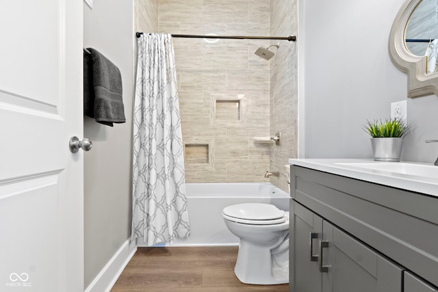 full bathroom featuring shower / bath combo, baseboards, toilet, wood finished floors, and vanity