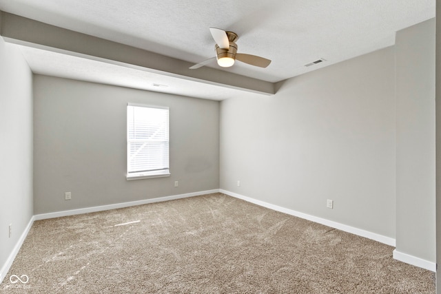 carpeted spare room featuring a ceiling fan, visible vents, a textured ceiling, and baseboards