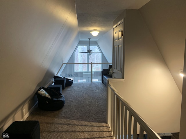 hall with carpet floors and vaulted ceiling