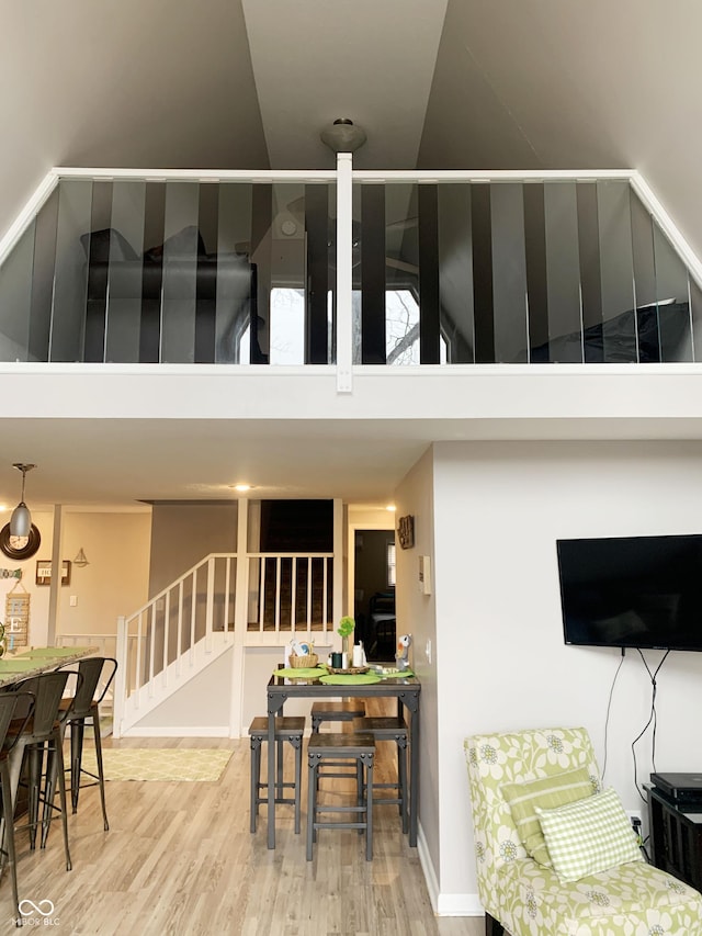 interior space with stairs, wood finished floors, and high vaulted ceiling