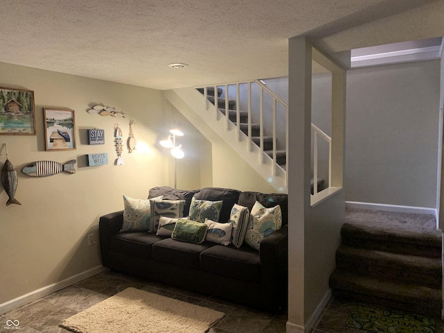 living room featuring a textured ceiling, stairs, and baseboards