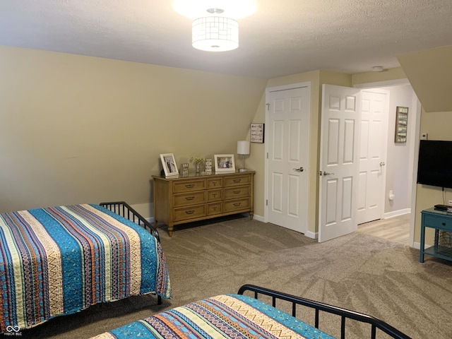 bedroom featuring carpet flooring, baseboards, and a textured ceiling