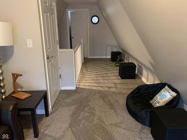 corridor featuring baseboards, lofted ceiling, and carpet