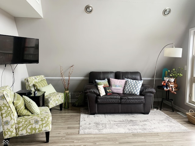 living area featuring baseboards and light wood finished floors