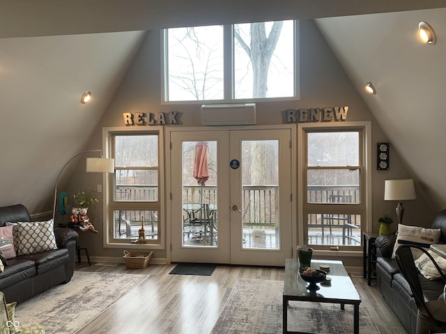 living area featuring a wall mounted air conditioner, french doors, high vaulted ceiling, and wood finished floors