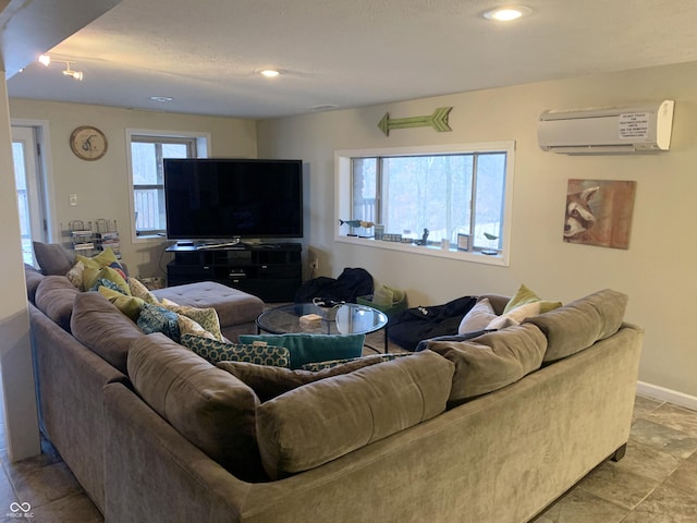 living area featuring recessed lighting, baseboards, and an AC wall unit