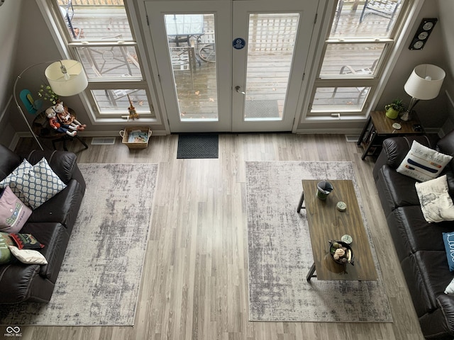 living room featuring wood finished floors, visible vents, and french doors