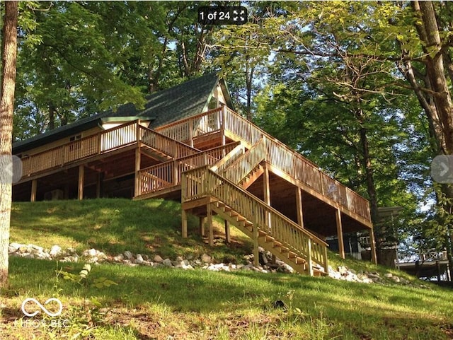 rear view of house with stairway and a wooden deck