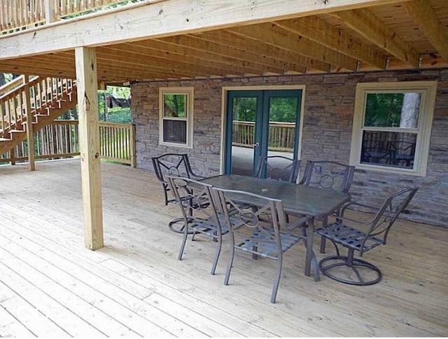 wooden terrace featuring outdoor dining area and stairway