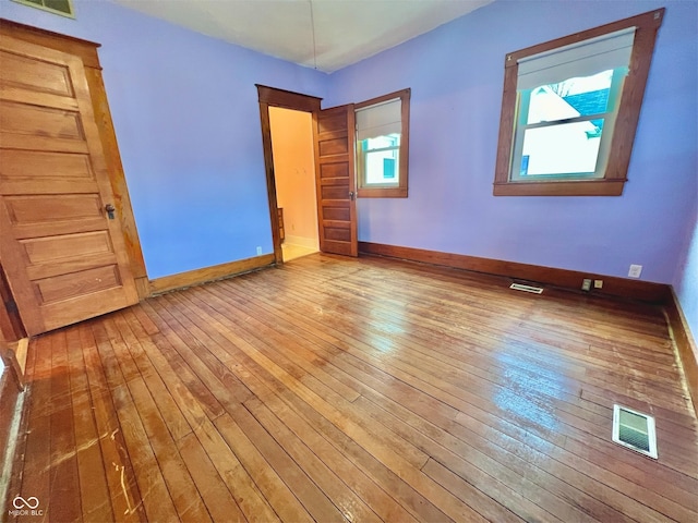 unfurnished bedroom with baseboards, visible vents, and hardwood / wood-style floors