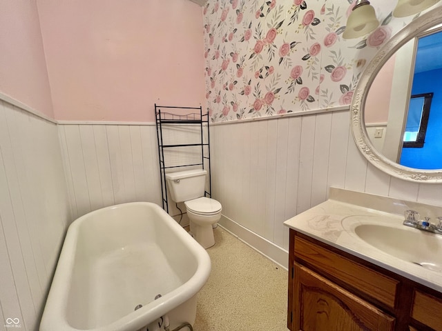 full bathroom featuring a soaking tub, wainscoting, vanity, and toilet