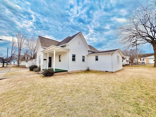 view of side of property with crawl space, a lawn, and roof with shingles