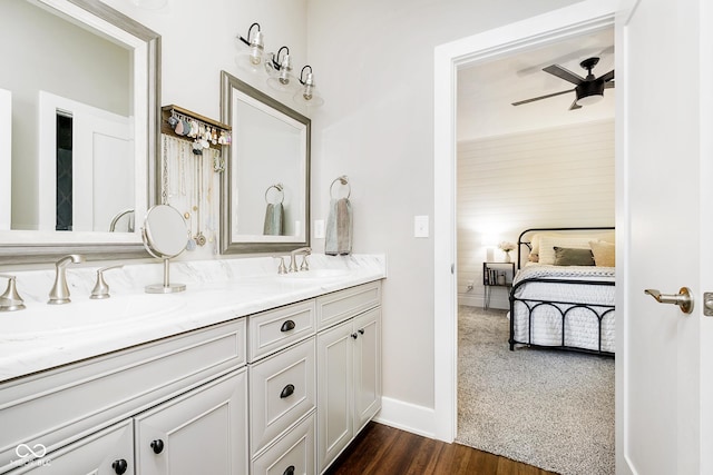 bathroom featuring a sink, connected bathroom, wood finished floors, and double vanity