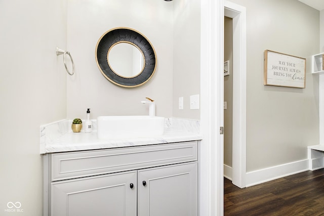 bathroom featuring vanity, wood finished floors, and baseboards