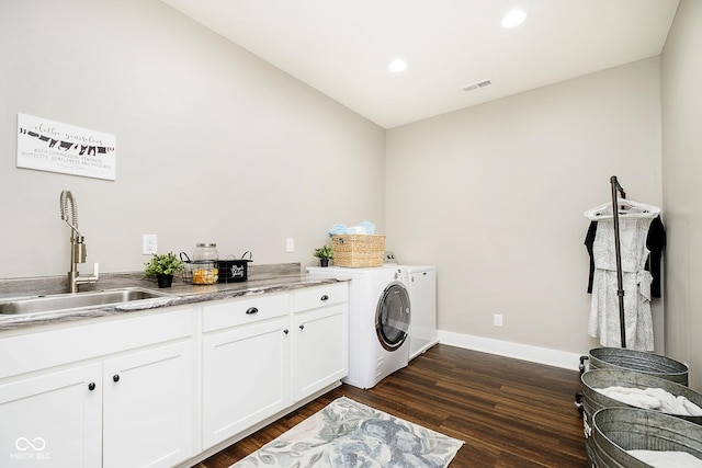 clothes washing area with a sink, cabinet space, separate washer and dryer, baseboards, and dark wood-style flooring