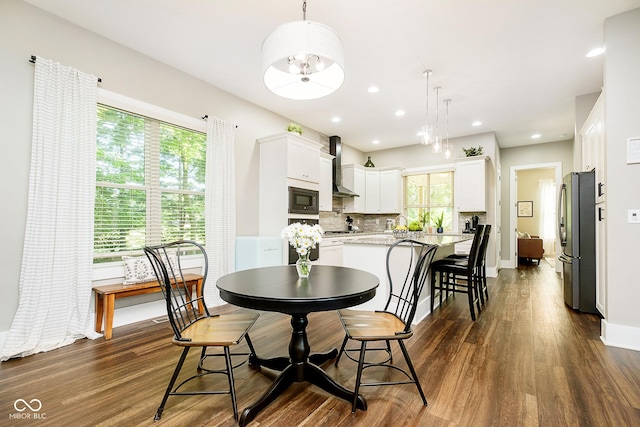 dining room with dark wood-type flooring, a notable chandelier, recessed lighting, and baseboards