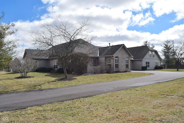 view of front of property with a front lawn and brick siding