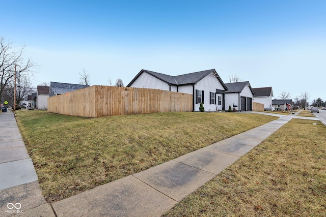 view of property exterior with a lawn, fence, and a residential view