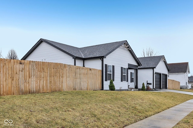 view of front facade featuring a garage, a front yard, concrete driveway, and fence