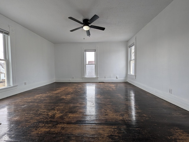 spare room with ceiling fan, a textured ceiling, baseboards, and wood finished floors