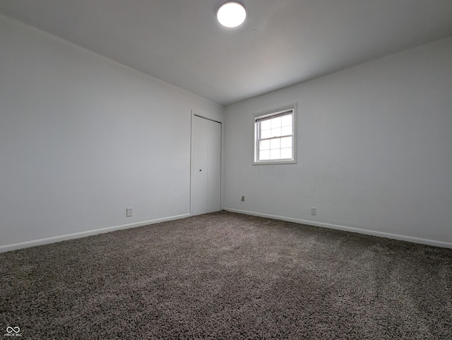 carpeted spare room featuring baseboards