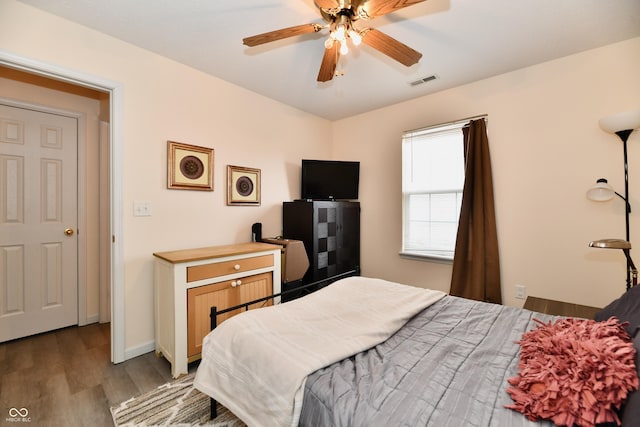 bedroom featuring light wood-style flooring, a ceiling fan, visible vents, and baseboards