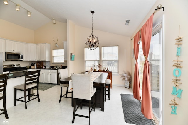 dining area featuring high vaulted ceiling, visible vents, and an inviting chandelier