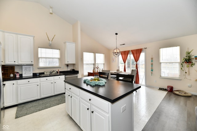 kitchen featuring dark countertops, a center island, and white cabinets