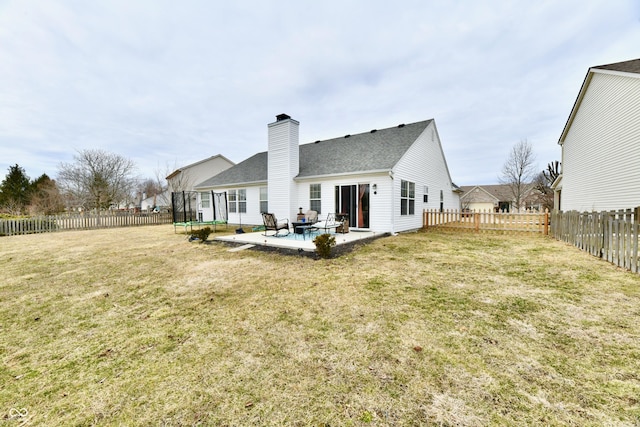 back of property featuring a trampoline, a fenced backyard, a patio, and a lawn