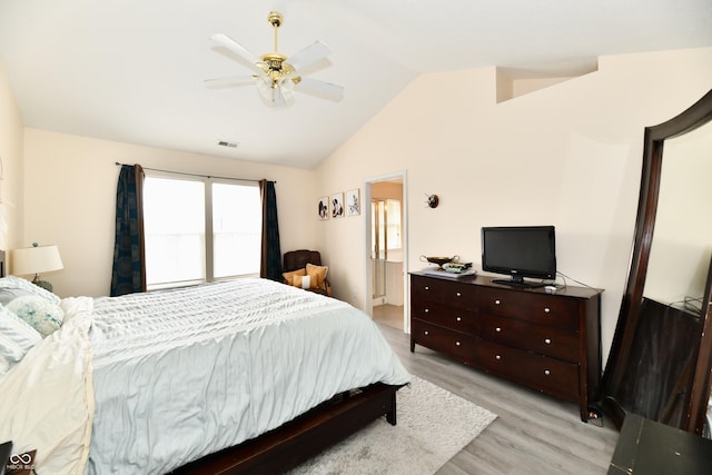 bedroom with visible vents, connected bathroom, a ceiling fan, vaulted ceiling, and light wood-style floors