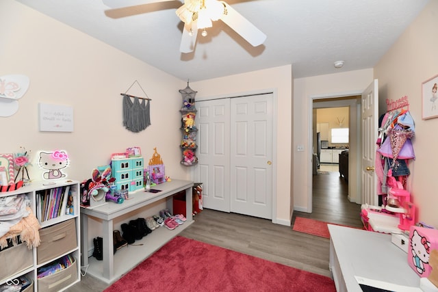 recreation room with a ceiling fan and wood finished floors