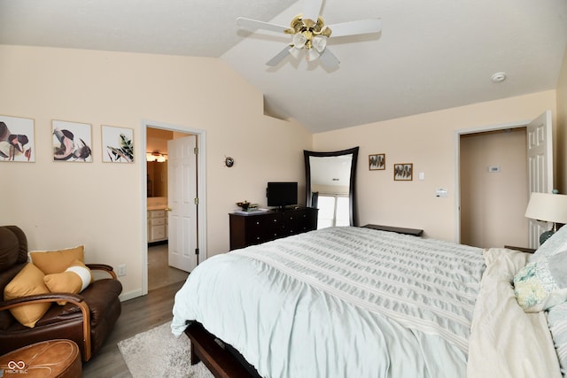 bedroom featuring vaulted ceiling, ceiling fan, wood finished floors, and connected bathroom