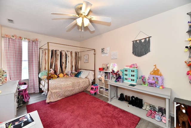 bedroom with ceiling fan, wood finished floors, and visible vents