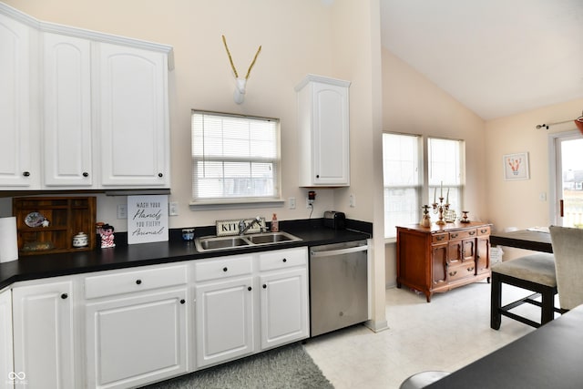 kitchen featuring dishwasher, dark countertops, lofted ceiling, white cabinetry, and a sink