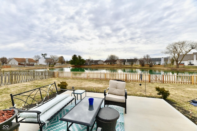 view of patio with a water view, a fenced backyard, and an outdoor living space with a fire pit