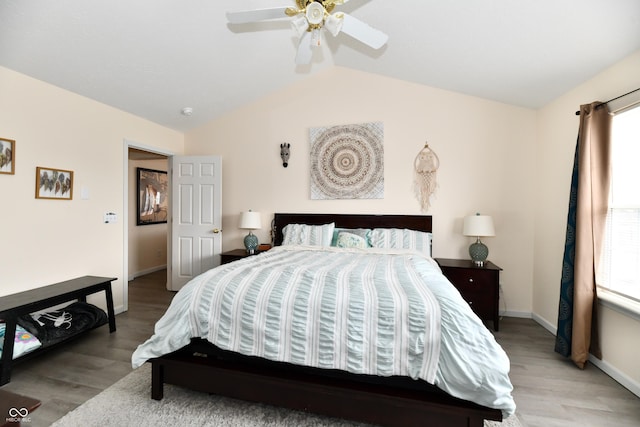 bedroom featuring lofted ceiling, multiple windows, and light wood-type flooring