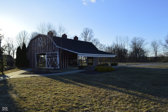 view of front facade featuring a front lawn, an outdoor structure, a barn, and a gambrel roof