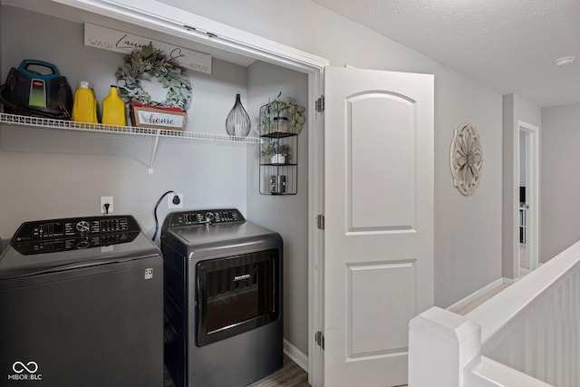 laundry room with laundry area, baseboards, washer and clothes dryer, and a textured ceiling