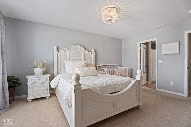 bedroom with baseboards, a textured ceiling, and light colored carpet